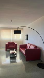 拉尔法斯德尔皮VIP Alfaz del Pi的客厅配有两张红色的沙发和一张桌子