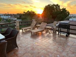 塞维利亚Balcon Buenavista的露台上的烧烤架和椅子享有日落美景