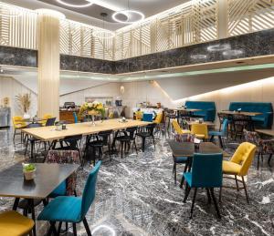 塞萨洛尼基埃尔格雷柯酒店的大型用餐室配有桌椅