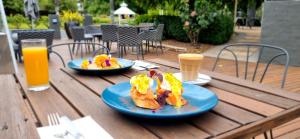 马奇Parklands Resort的一张桌子,上面放着两盘食物和两杯橙汁