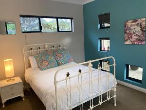 格纳拉巴普岩石泳池度假屋的卧室配有白色的床和蓝色的墙壁