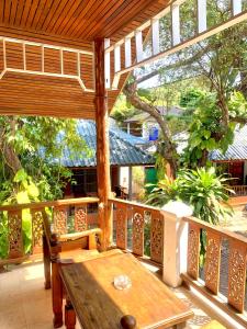 涛岛苏梅岛热带度假酒店的门廊上的木甲板上配有木桌和椅子