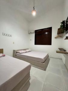 帕里普埃拉Casa Amarela Paripueira的一间卧室设有两张床和窗户。