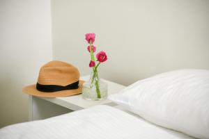 特拉维夫דירות גני תערוכה - TLV university apartments near Expo by Sea N' Rent的床上的帽子和花瓶