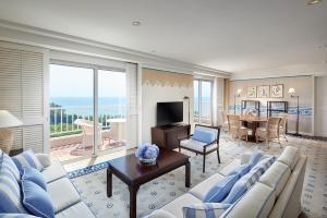 西归浦市济州岛新罗酒店的客厅配有蓝色和白色家具和桌子