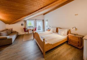 米滕瓦尔德多灵酒店的一间卧室配有一张大床和一张沙发