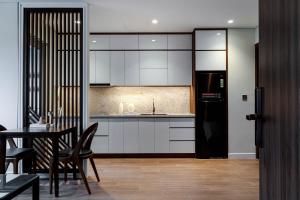 岘港MK Riverside Apartment by Haviland的厨房配有白色橱柜和黑色冰箱。