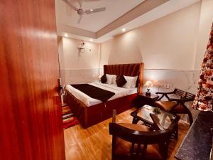穆索里Doon Valley Resort, Mussoorie的卧室配有一张床和一张桌子及椅子