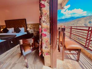 穆索里Doon Valley Resort, Mussoorie的客房设有一张床和一个美景阳台