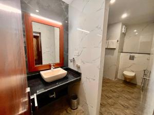 穆索里Doon Valley Resort, Mussoorie的一间带水槽、卫生间和镜子的浴室