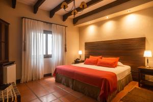 萨尔塔贝肯德拉广场精品酒店的一间卧室配有一张带橙色枕头的大床