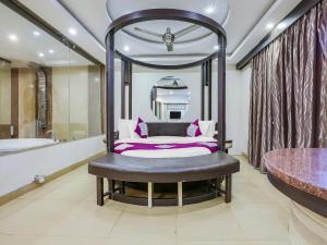 卡兰古特Grandeur De Sanchi- Luxury Beach Resort & Spa的卧室配有1张床、浴缸和镜子