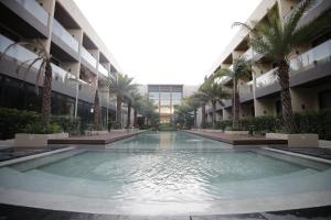 卡瓦延市The Maximilian Hotel的棕榈树建筑中间的游泳池