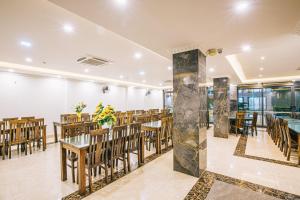 岑山Maldives Hotel - FLC Sầm Sơn的一间在房间内配有桌椅的餐厅