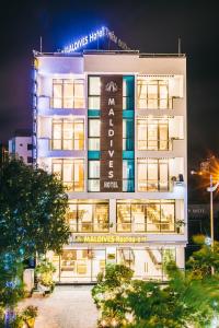 岑山Maldives Hotel - FLC Sầm Sơn的一座白色的大建筑,上面有标志