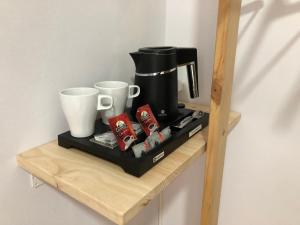 毕尔巴鄂瑟兰特斯休闲旅馆的咖啡壶和木架上的两杯