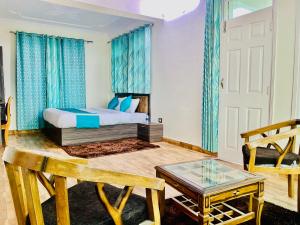 西姆拉Staynest Mashobra with balcony- A peacefull stay的一间卧室配有一张带蓝色窗帘的床和一张桌子