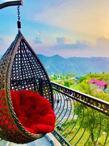 西姆拉Staynest Mashobra with balcony- A peacefull stay的阳台上配有带红色枕头的吊床