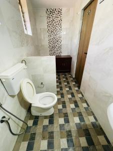 科尔瓦Colva Beach Samaira GuestHouse & Apartments的一间带卫生间的浴室和瓷砖地板。