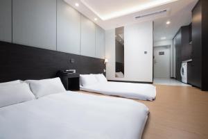 丽水市Utop Marina Hotel & Resort的配有白色床单的酒店客房内的两张床