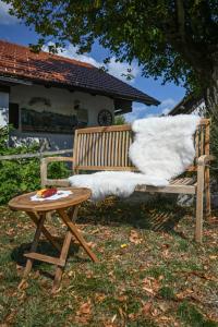 Ivančna GoricaHoliday Farm Grofija的一张带桌子和白色毯子的木凳