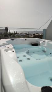 卡马利蓝色梦幻圣托里尼公寓的配有水的浴缸,享有海景
