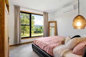 穆伦宾比Gan Eden Retreat-Byron bay , luxuries escape的一间卧室设有一张床和一个大窗户