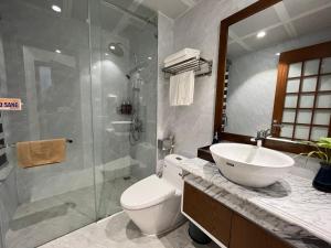 下龙湾Samatha Hotel Bai Chay, Ha Long的浴室配有卫生间、盥洗盆和淋浴。