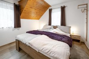 佐尔尼耶戈迪Apartmaji Koza的一间卧室设有一张带木制天花板的大床