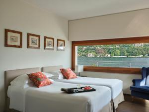科莫弗罗瑞别墅酒店的带大窗户的客房内的两张床