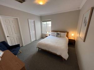 珀斯Beachy Vibes in Karrinyup的一间卧室设有一张大床和一个窗户。