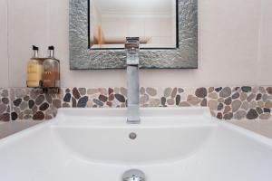 卡迪夫higgihaus #5 Room 5 Monday - Friday的浴室水槽设有水龙头和镜子