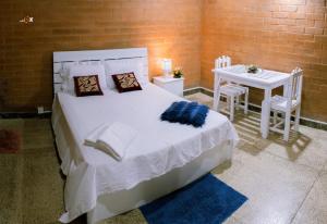 马拉维拉Sevenday Hotel的卧室配有一张白色的床和桌椅