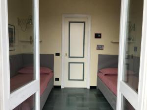 圣玛格丽塔-利古雷Solimano 50的一间设有两张床的客房和一个带镜子的门