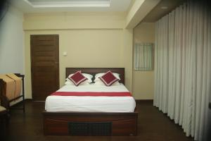 阿努拉德普勒Shanthi Villa Resort的一间卧室配有一张带两个枕头的床
