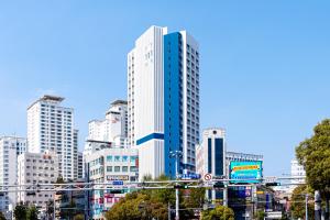 釜山Urbanstay Busan Cityhall的一座高大的白色建筑,在城市里