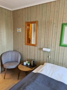 贝勒沃格Berlevåg Motell AS的一间卧室配有一张床、一把椅子和一张桌子