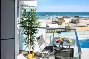 马马亚Vlezal Apartment Spa&Pool Beach Resort的海滩阳台的餐桌上摆放着一盘食物
