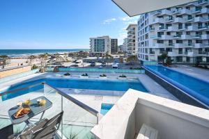 马马亚Vlezal Apartment Spa&Pool Beach Resort的一个带游泳池和大楼的阳台