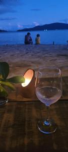 帕拉蒂REFUGIO na frente do mar em Ilha de Araujo的坐在海滩的桌子上喝一杯葡萄酒