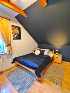 Czajowice卡尔兹玛梅斯业奥卡宾馆的一间卧室设有一张床和蓝色的墙壁