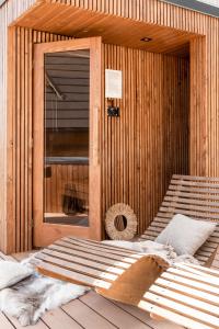 Białka TatrzanskaDomki w Białce WOODHOUSE- basen, sauna, jacuzzi的门前设有一张床铺的木制桑拿房