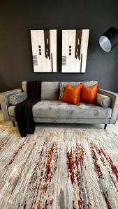 约翰内斯堡Stylish Executive Apartment with Power Backup的客厅配有带橙色枕头的灰色沙发