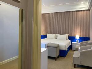 日惹Madina Inn Hotel的配有一张床和一把椅子的酒店客房