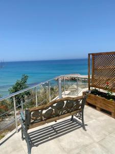 凯里尼亚Sunside Inn Hotel的一张长凳,位于一个俯瞰大海的阳台