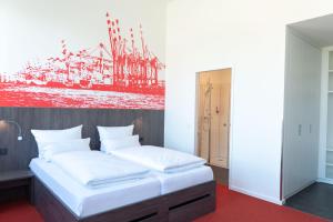 不来梅港布莱梅港哈维酒店的一间卧室配有一张壁画床
