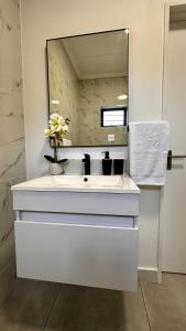 约翰内斯堡Stylish Executive Apartment with Power Backup的浴室设有白色水槽和镜子