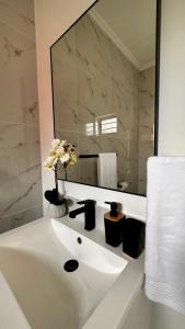 约翰内斯堡Stylish Executive Apartment with Power Backup的白色的浴室设有水槽和镜子