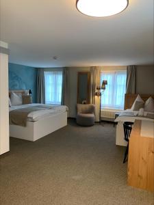 韦登斯维尔恩格尔班霍夫酒店的一间大卧室,配有一张大床和一张沙发
