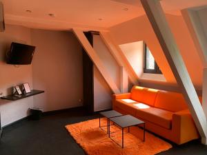 Conques-en-RouergueMoulin de Cambelong- Emilie & Thomas的客厅配有橙色沙发和电视